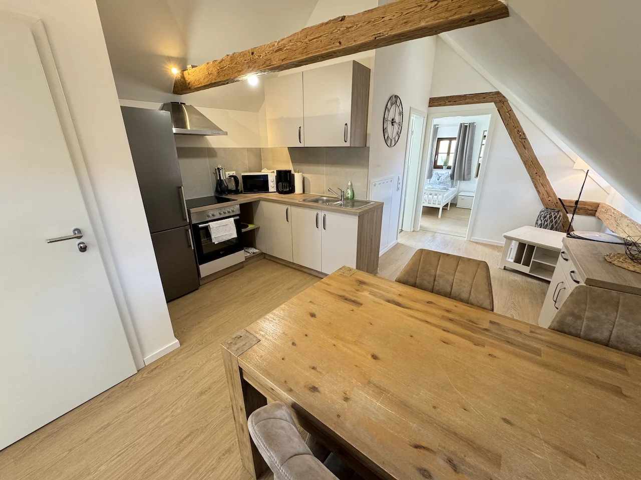 Wohn- und Essbereich im Apartment der Laurent Ranch in Gottfrieding mit Esstisch, Einbauküche und Holzbalkendecke