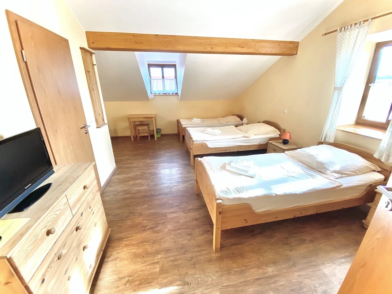 Mehrbettzimmer mit hellen Holzbetten in der Pension Laurent Ranch in Gottfrieding