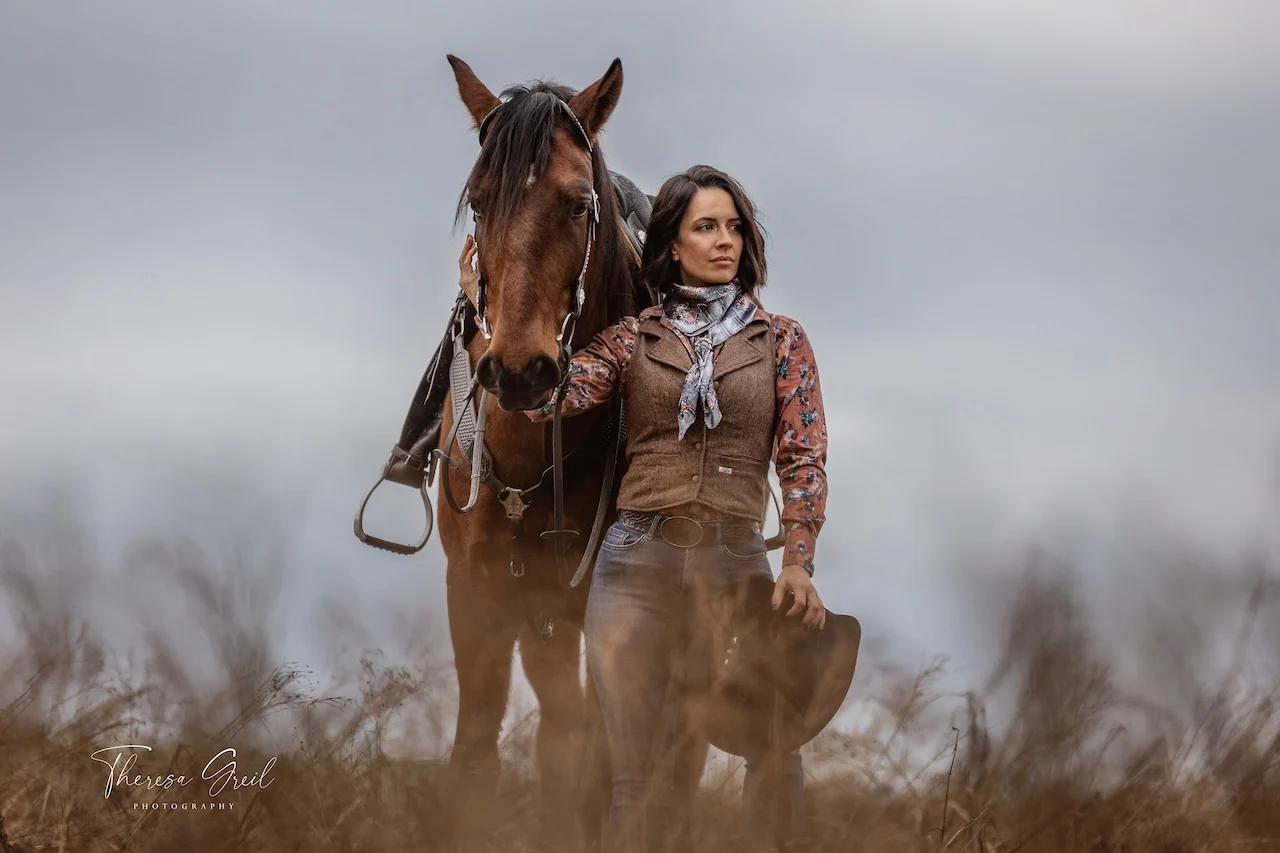 Selina Hempel mit einem gesattelten Pferd auf der Koppel der Laurent Ranch in Gottfrieding